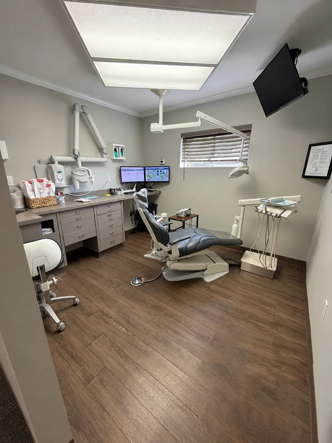A dental treatment room with a chair and overhead light at Bencaz Family Dentistry.