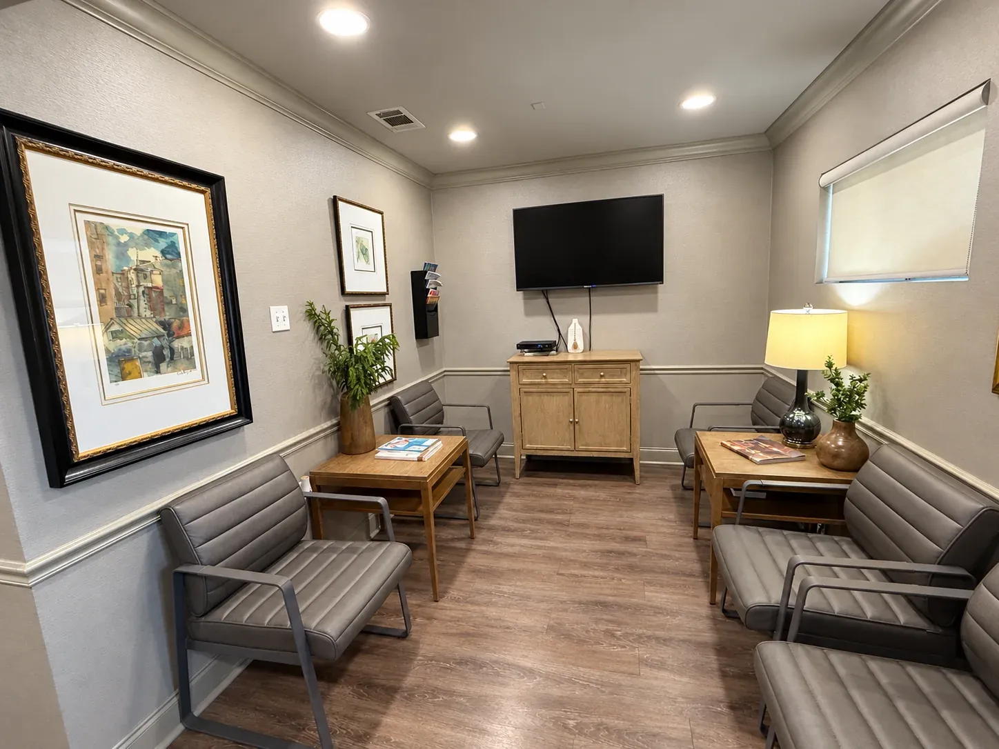 The Bencaz Family Dentistry waiting room with upholstered seating and artwork.